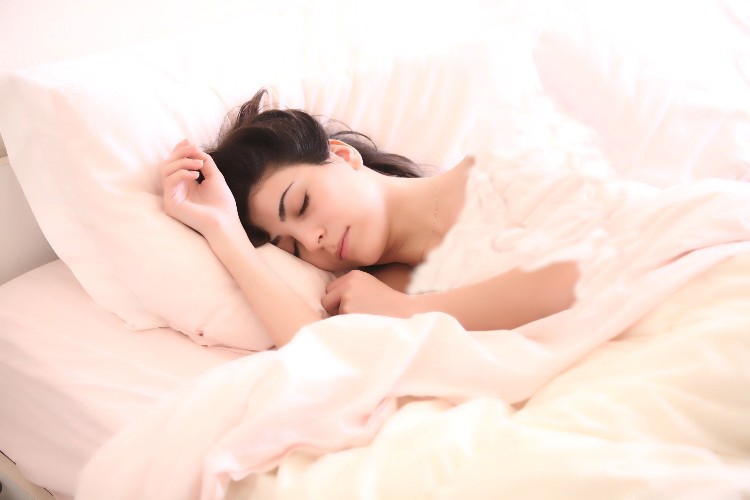 Frau liegt im Bett und träumt